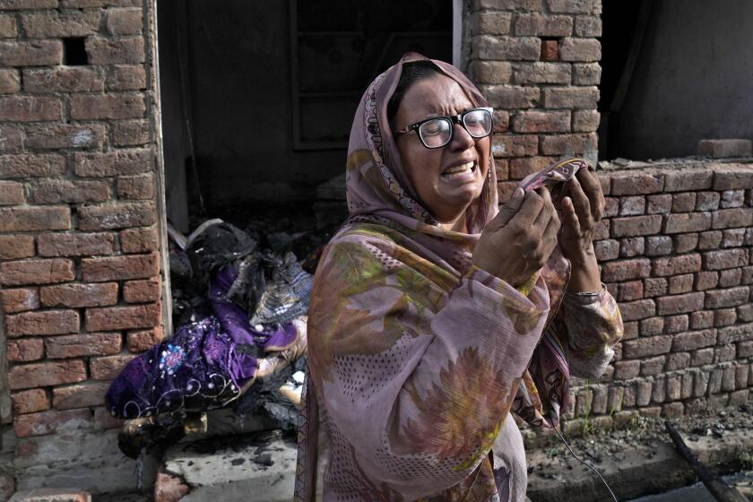 A Christian woman weeps after looking at her home vandalized by an angry Muslim mob in Jaranwala in the Faisalabad district, Pakistan, Thursday, Aug. 17, 2023. Police arrested more than 100 Muslims in overnight raids from an area in eastern Pakistan where a Muslim mob angered over the alleged desecration of the Quran by a Christian man attacked churches and homes of minority Christians, prompting authorities to summon troops to restore order, officials said Thursday. (AP Photo/K.M. Chaudary)
