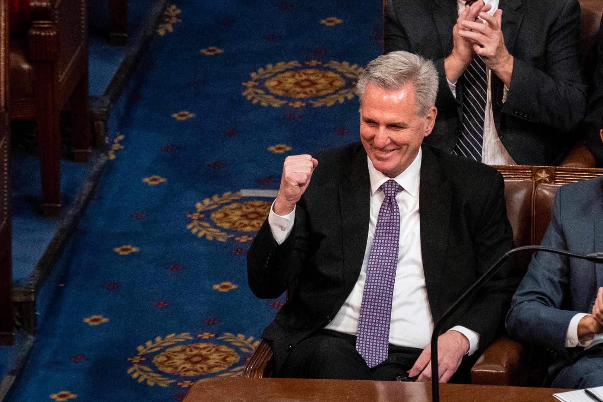 Kevin McCarthy pumping his fist as he sits in the House chamber.