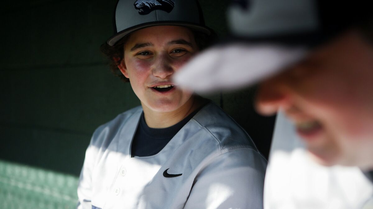 Jake Hofheimer shares a laugh with a teammate in the dugout during a New Roads High game.