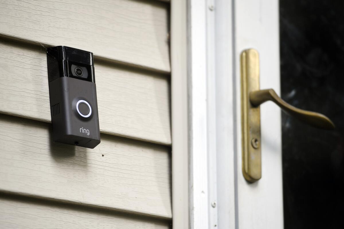 A camera doorbell next to a front door.