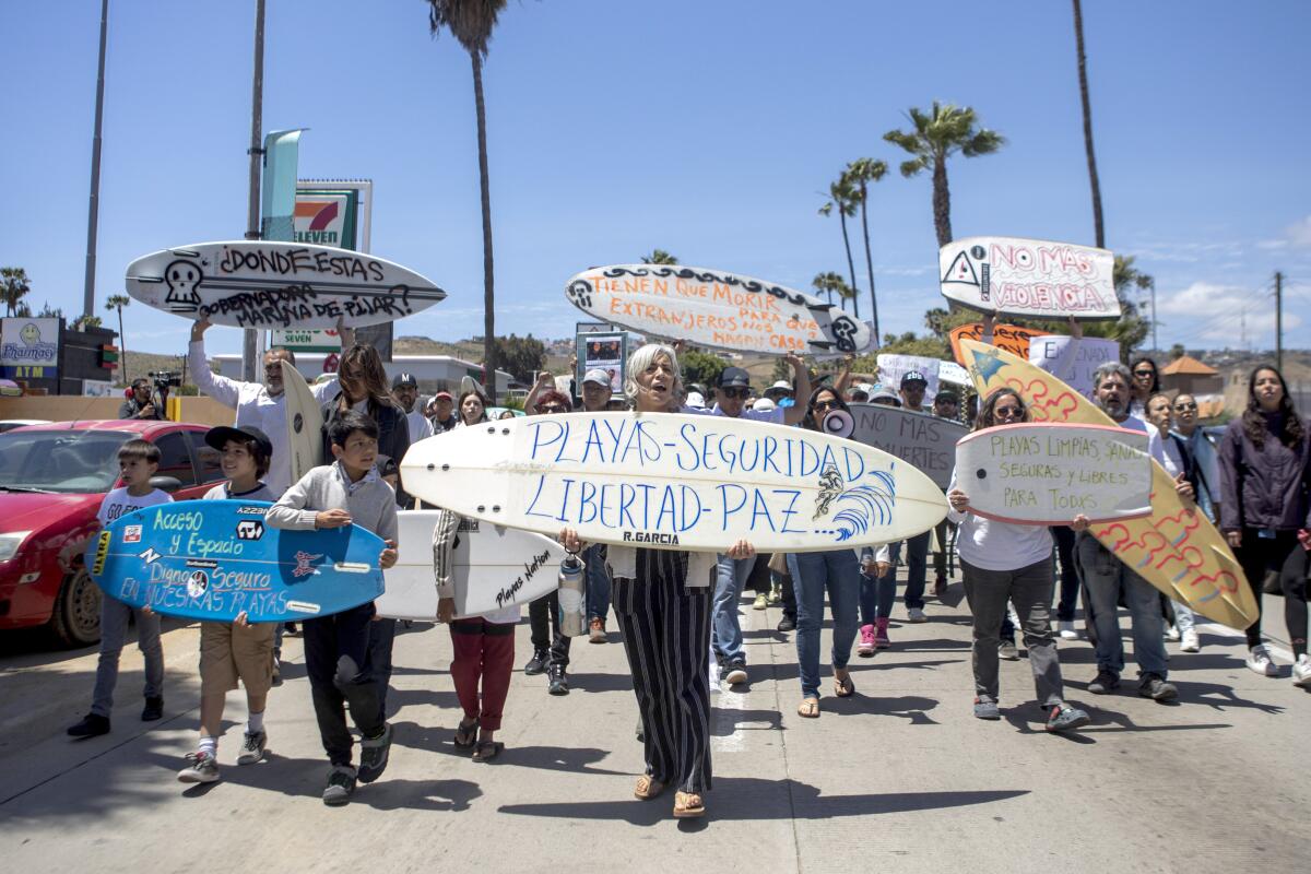 Locals march to protest the disappearance of foreign surfers in Ensenada, Mexico.