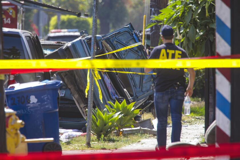 Los Angeles, CA - July 01: A car on its side flipped by the force of fireworks explosion on 700 block of 27th. Street in Los Angeles. LAPD and federal ATF investigators at the scene to determine what caused a huge explosion that injured 17 people, including 10 law-enforcement officers, after police attempted to safely detonate illegal fireworks that were seized at a house on 700 block of East 27th. Street on Thursday, July 1, 2021 in Los Angeles, CA. (Irfan Khan / Los Angeles Times)