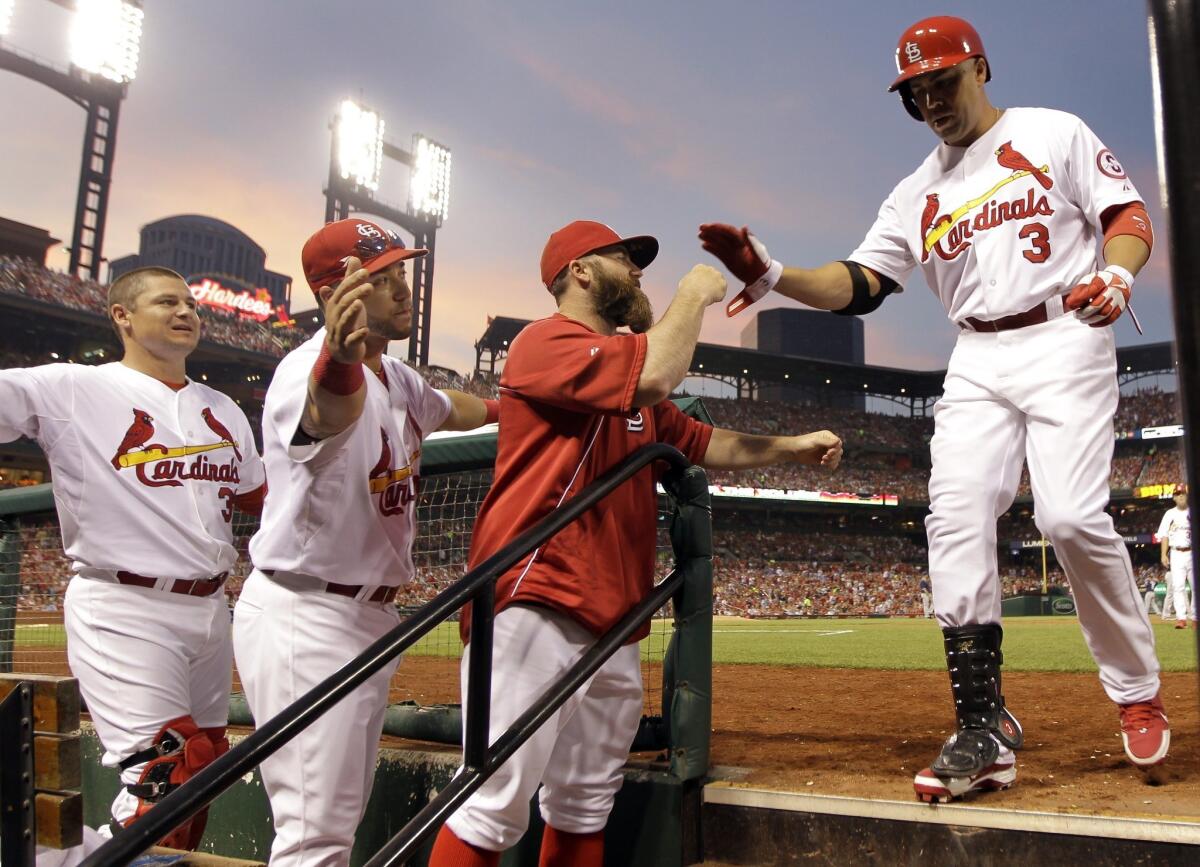 St. Louis Cardinals' Carlos Beltran, right, is congratulated by teammates, from left to right, Rob Johnson, Tony Cruz and Jason Motte after hitting a sacrifice fly against the San Diego Padres on Friday night.