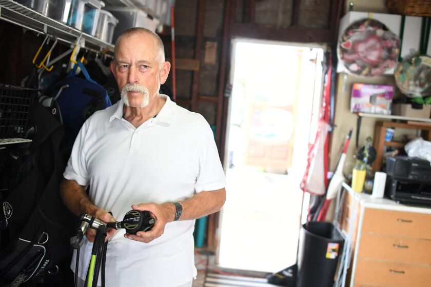 TORRANCE, CALIFORNIA SEPTEMBER 4, 2019- Dale Sheckler holds his diving gear in the garage of his Torrance home. Sheckler The longtime diver planned to join the Labor Day weekend excurion aboard the Conception. (Wally Skalij/Los Angeles Times)
