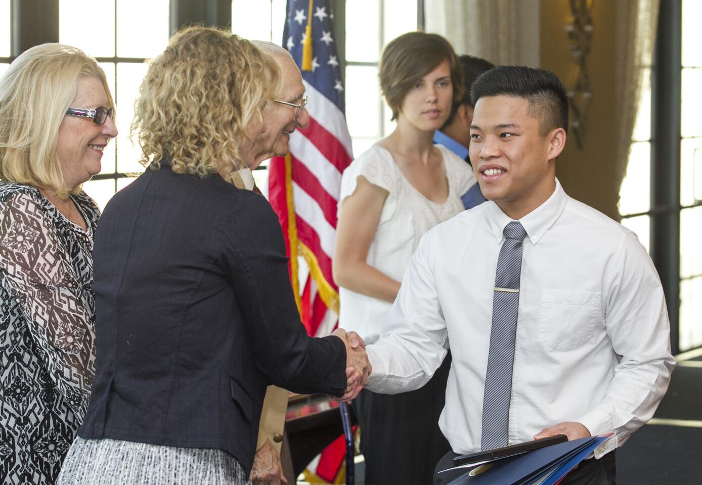 Estancia High School's Thanh Nugyen shakes hands with Katrina Foley during the 35th annual Scholarship Recognition Breakfast, hosted by the Costa Mesa Chamber of Commerce on Friday, May 16. He received the Les Miller Outstanding Student Award. (Scott Smeltzer - Daily Pilot)