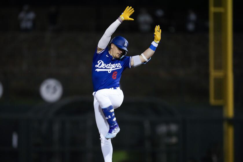 The Dodgers' Kiké Hernández celebrates after doubling during a spring training game against the Cleveland Guardians