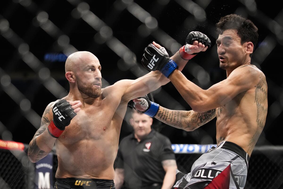 Alexander Volkanovski, left, hits Max Holloway in a featherweight title bout during the UFC 276 mixed martial arts event Saturday, July 2, 2022, in Las Vegas. (AP Photo/John Locher)