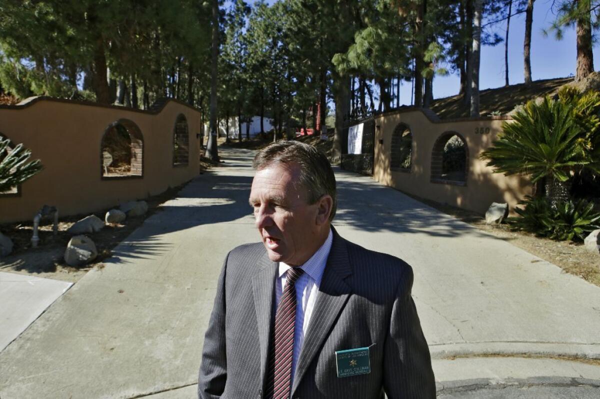 Los Angeles County Sheriff's Lt. Dave Coleman speaks to news media in front of a La Verne estate where an elderly couple was found beaten and stabbed.