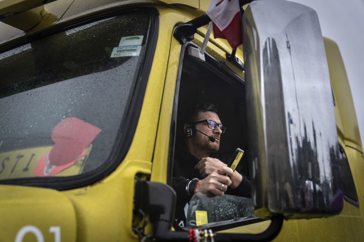 A man looking out the open window of a truck.