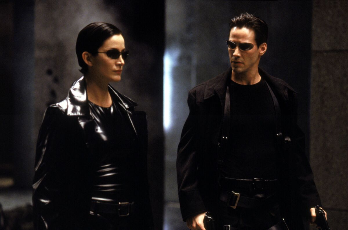 Carrie-Anne Moss as Trinity, left, and Keanu Reeves as Neo in Warner Bros' futuristic action-thriller "The Matrix."