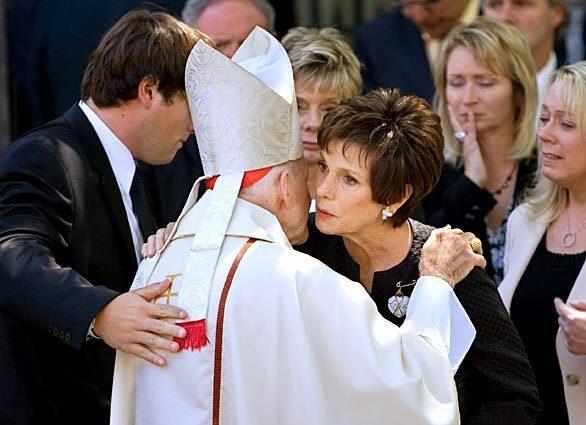 Maureen Orth, right, wife of the late Tim Russert, and son Luke Russert, left, are comforted by Archbishop Emeritus of Washington Theodore McCarrick after the funeral Mass for the late host of NBC's "Meet the Press," at Holy Trinity Church in the Georgetown neighborhood of Washington.