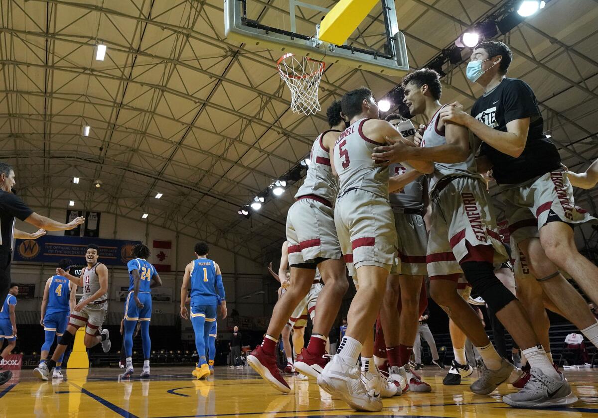 Stanford's Oscar da Silva, second from right, celebrates with teammates after his game-winning shot Jan. 23, 2021.