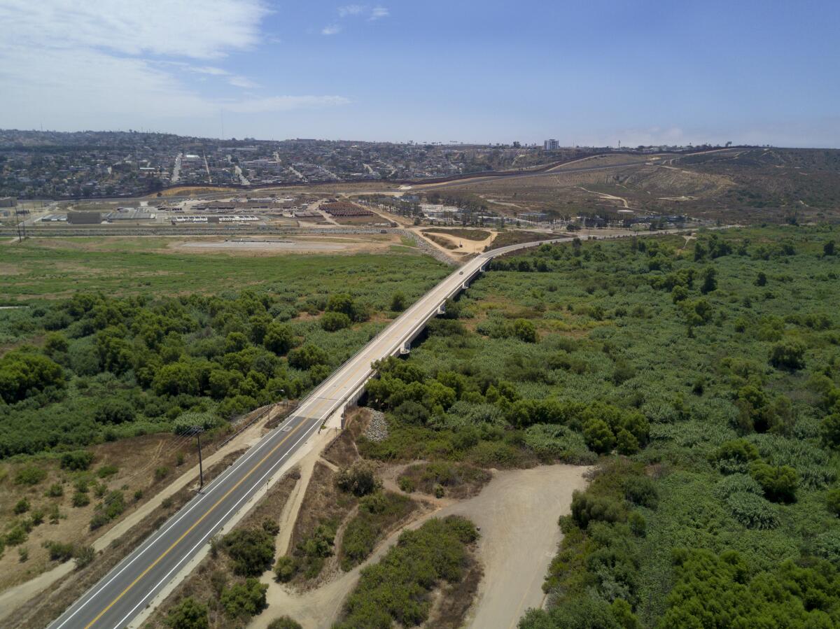 A section of Dairy Mart Road bridges over the Tijuana River in south San Diego with the U.S.-Mexico border in the background.