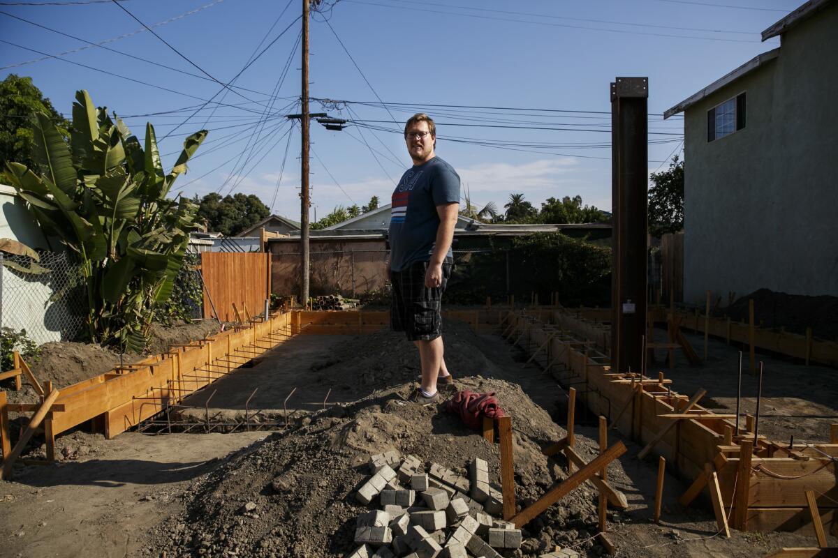 John Gregorchuk stands amid construction of a secondary dwelling unit that has been stalled in his backyard in Los Angeles.