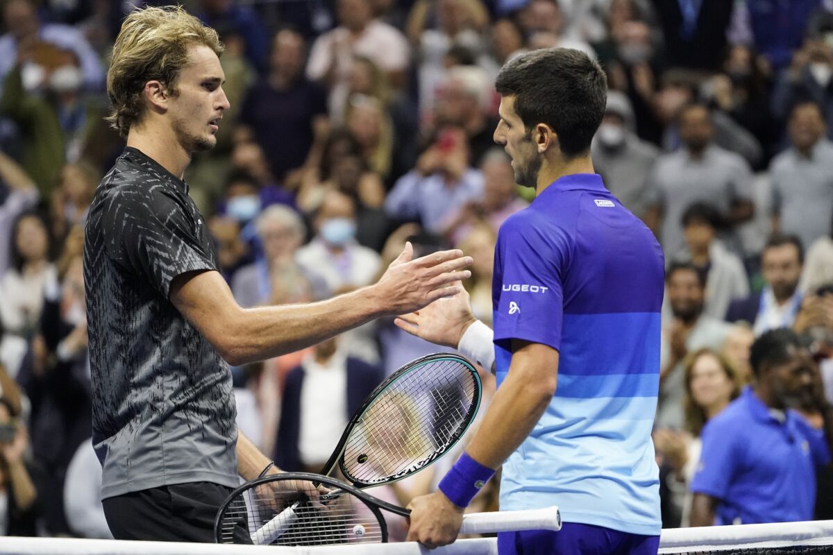 Novak Djokovic, right, shakes hands with Alexander Zverev after defeating Zverev on Sept. 10, 2021.