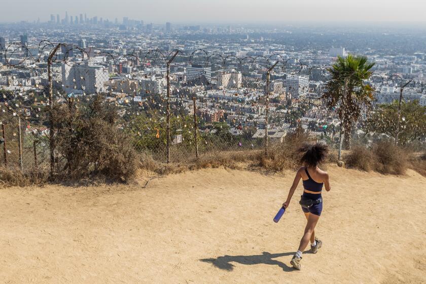 LOS ANGELES, CALIFORNIA - OCTOBER 3: A woman hikes at the Runyon Canyon Park on October 3, 2024 in Los Angeles, California. A heatwave is continuing to bring temperatures above 100 dreeges and an increased fire threat to Southern California. (Photo by Apu Gomes/Getty Images)