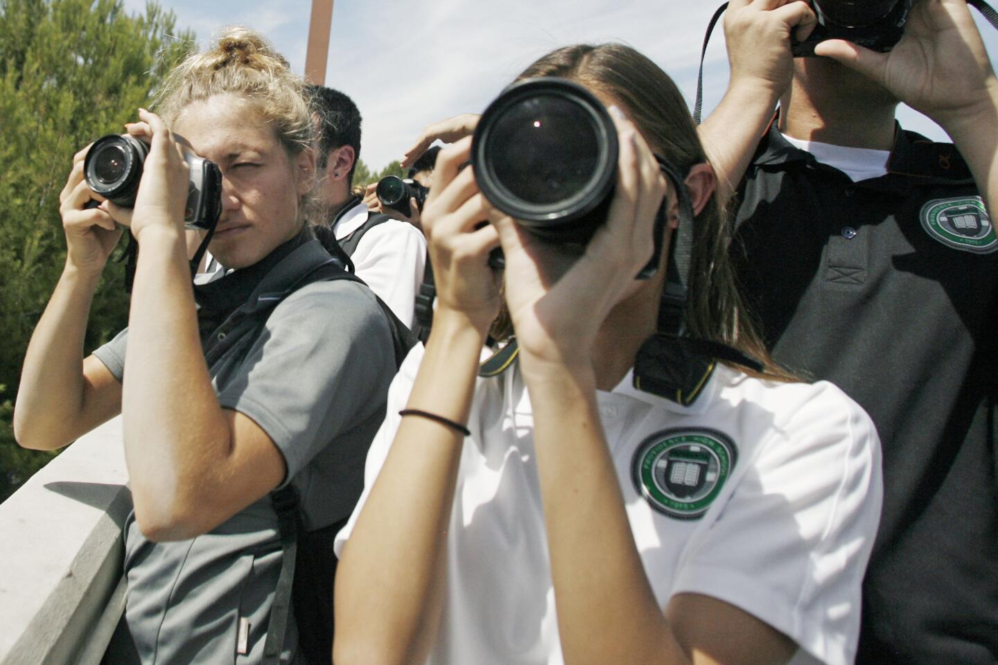 Photography students Marylin Petrov, 17, left, and Taylor Goffin, 14, take pictures of Endeavour as it flies near Providence High School in Burbank on Friday, September 21, 2012.