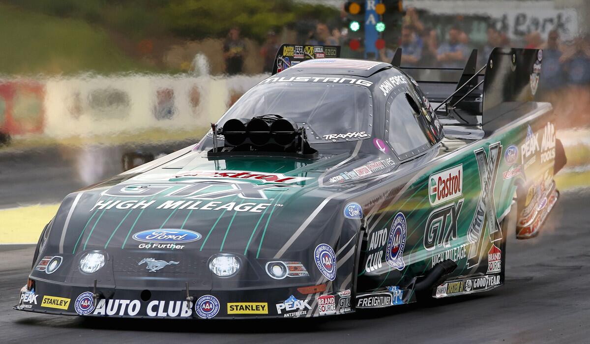 Funny Car driver John Force makes a qualifying run for the NHRA Kansas Nationals on May 23, 2014.