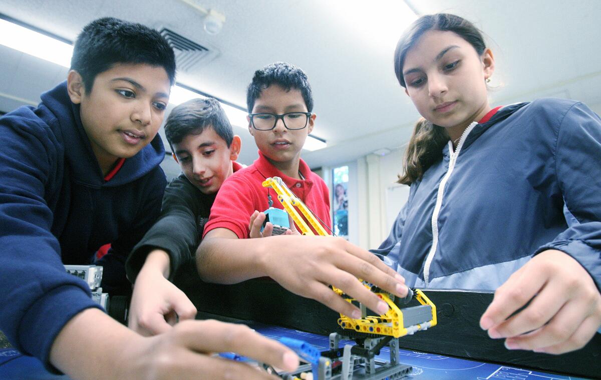 Ibrahim Ahmad, 13, Avakeem Avakian, 11, Alexander Sebastian, 12, and Diana Lopez, 12, work together on a Lego robot in Randy Kamiya's robotics classroom at Roosevelt Middle School on Monday.