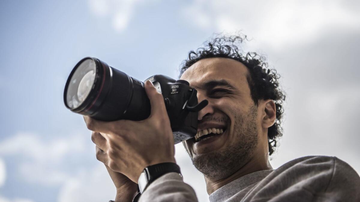 Egyptian photojournalist Mahmoud Abou Zeid, widely known as Shawkan, carries a camera outside his home in Cairo on March 4.