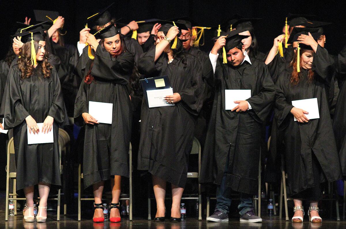 Graduates of the Burbank Adult School move their tassels from the right side to the left after they are conferred at the graduation at Luther Burbank Middle School on Wednesday, May 28, 2014.