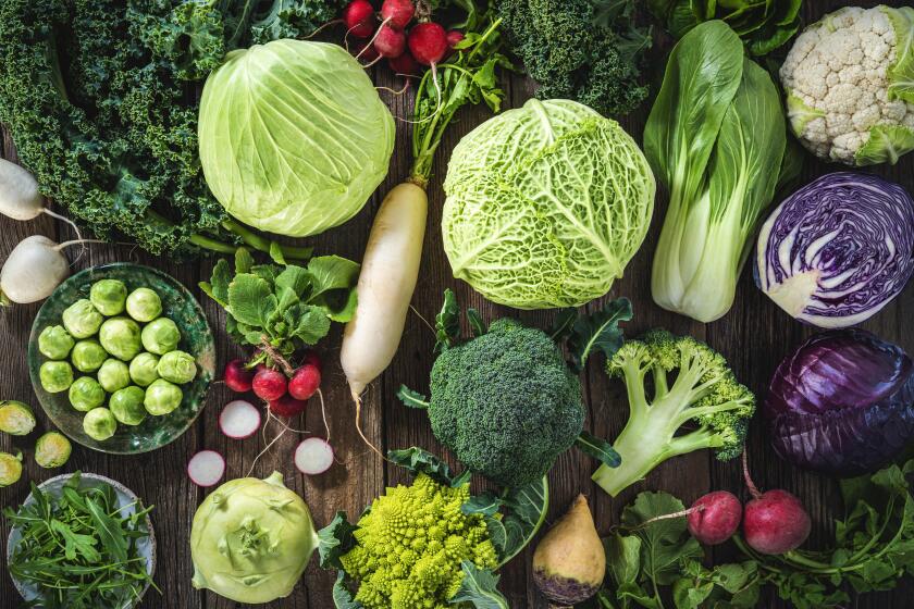 Crucifers vegetables assortment including cabbage, broccoli, cabbage, turnip, kale, romanesco, radish, arugula, kohlrabi and swedes on wood rustic board full frame