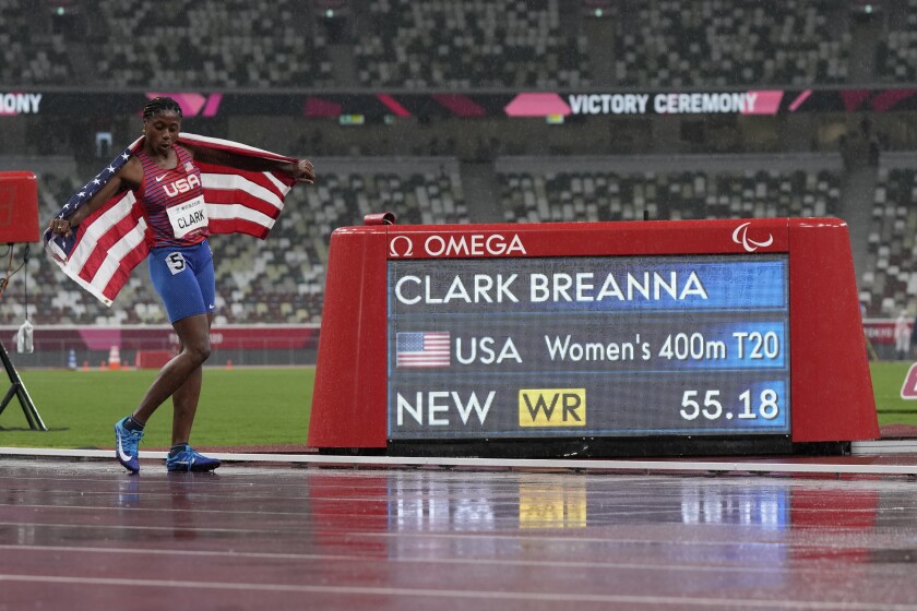 Breanna Clark celebrates next to the scoreboard showing her world record.