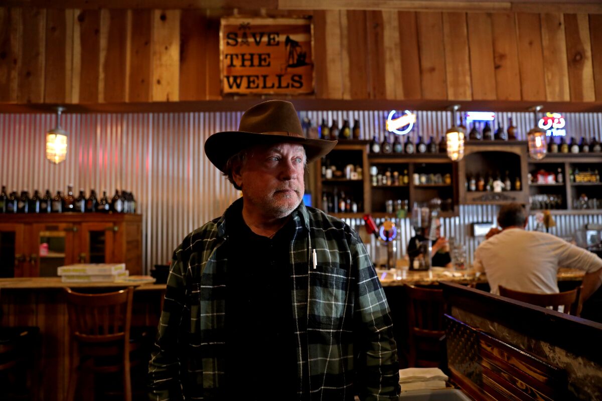 A man stands in front of a bar