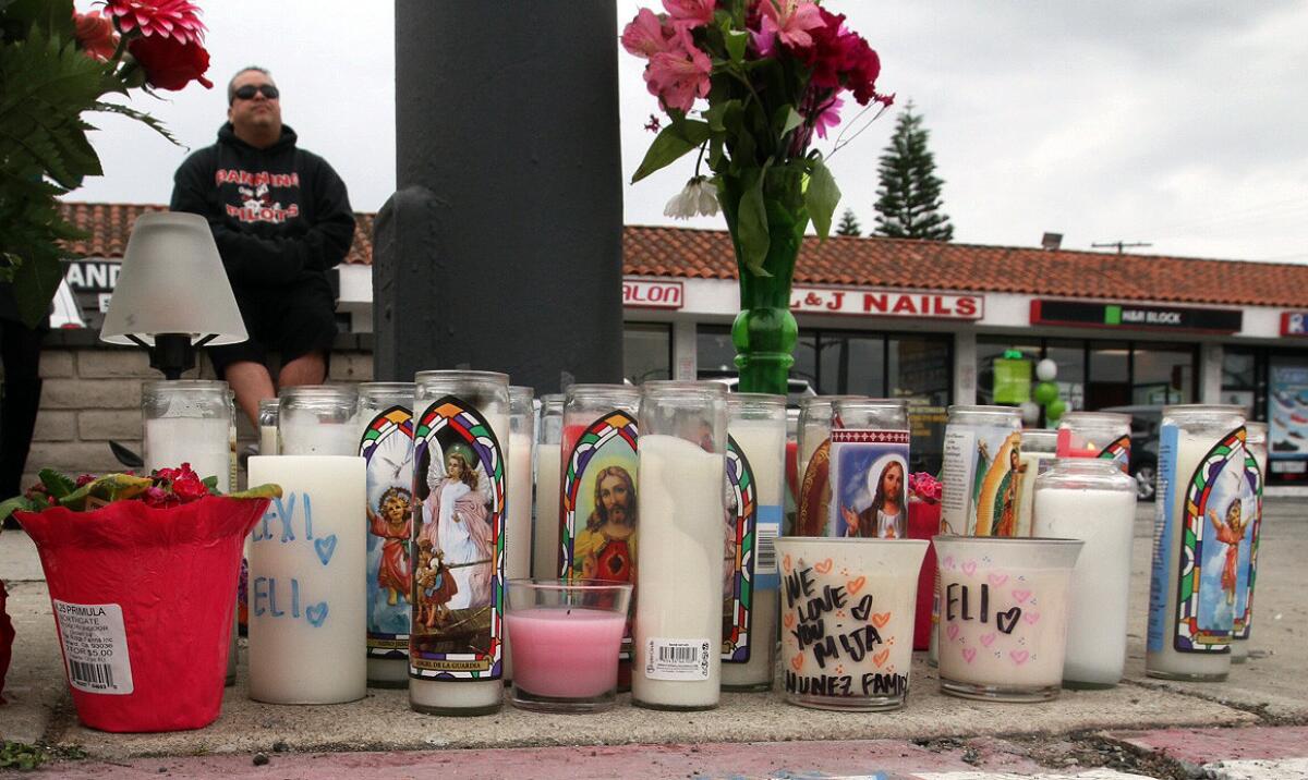 Gilberto Huerta sits at memorial to a brother and sister killed in a two-vehicle crash at 350 W. Pacific Coast Highway, near Island Avenue in Wilmington.