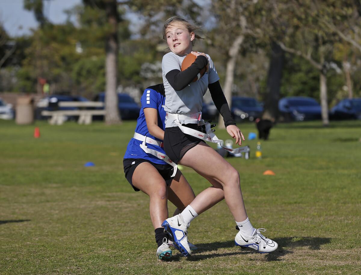 Anna Sofia Dickens spins and eludes a "tackler" during Wednesday's Seals 13U girls' flag football practice.