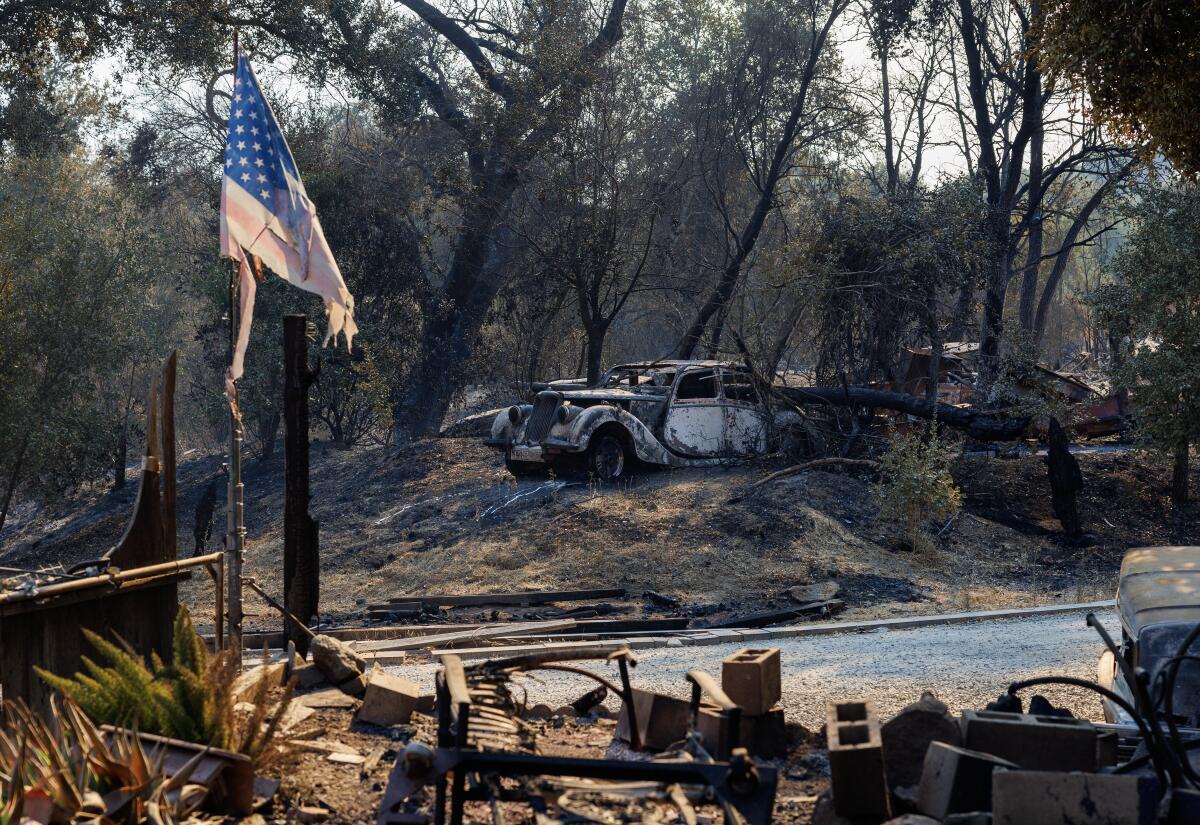 Tattered American flag still hangs on Lake Elsinore property where a home and vintage cars were destroyed by Airport fire.