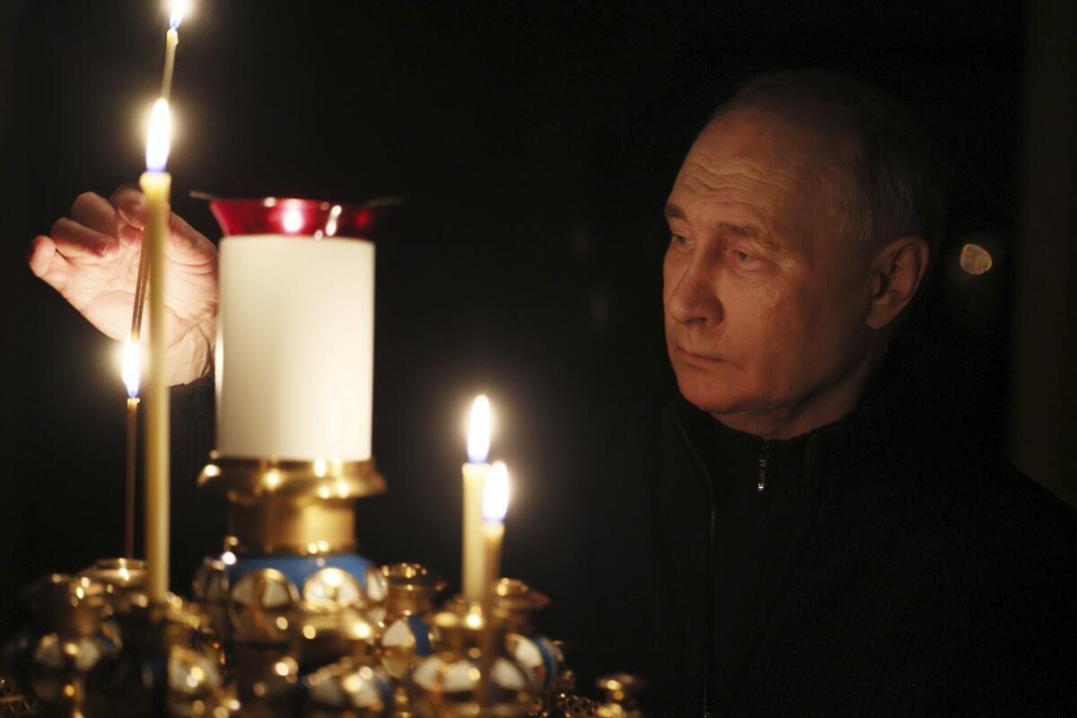 ロシアのウラジーミル・プーチン大統領がろうそくに火を灯す。
