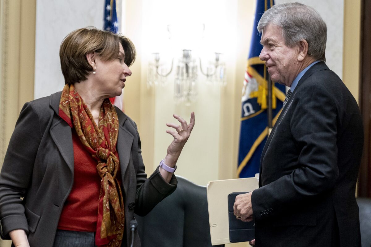 Chairman Sen. Amy Klobuchar, D-Minn. speaks with Ranking Member Sen. Roy Blunt, R-Mo., after U.S. Capitol Police Inspector General Michael Bolton appeared before a Senate Rules and Administration Committee oversight hearing on the Jan. 6, attack on the Capitol, on Capitol Hill in Washington, Tuesday, Dec. 7, 2021. (AP Photo/Andrew Harnik)