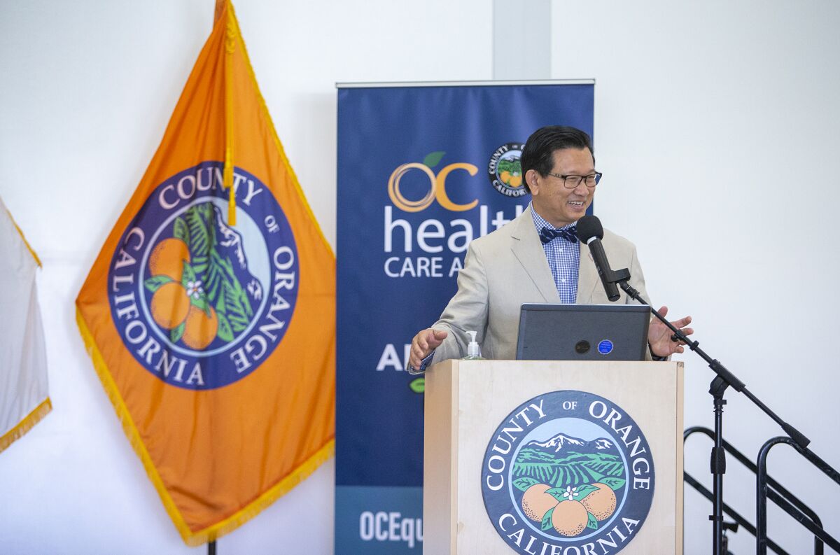 Andrew Do speaks at a lectern with the seal of Orange County behind him.