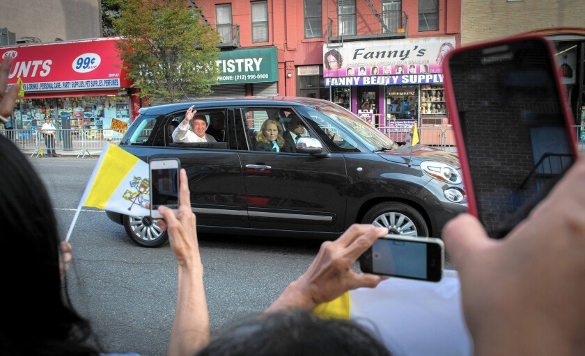 Pope Francis waves from the back seat of a Fiat during his visit to New York. The symbolism of the simple car resonated as powerfully as any of his speeches.