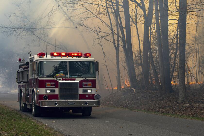 A Rockingham County fire engine drives along Peake Mountain Road during a wildfire, Wednesday, March 20, 2024, near Rawley Springs, Va. (Daniel Lin/Daily News-Record via AP)