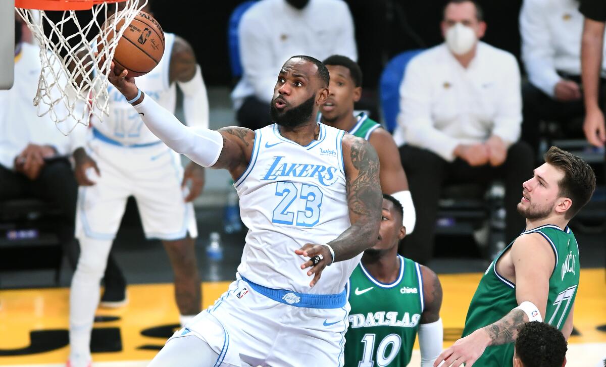 Lakers star LeBron James drives through the Dallas Mavericks defense to score on a layup.