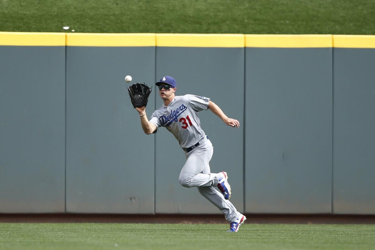 Dodgers center fielder Joc Pederson makes a running catch to snag a ninth inning fly ball against the Reds.