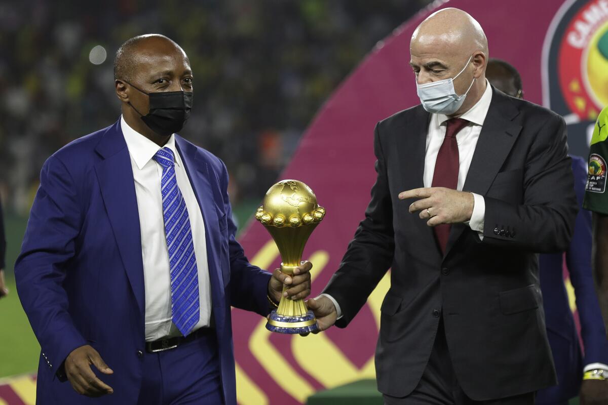 FILE - Confederation of African Football President Patrice Motsepe, left, and FIFA President Gianni Infantino hold the African Cup of Nations 2022 trophy after the final soccer match between Senegal and Egypt at the Olembe stadium in Yaounde, Cameroon, Feb. 6, 2022. Motsepe is set to launch a 24-club super league that he has promised will revolutionize soccer on the continent and become its richest competition. The scheduled launch later Wednesday, Aug. 10, 2022, will come as Motsepe's organization reported a loss of nearly $50 million last year. (AP Photo/Sunday Alamba, File)