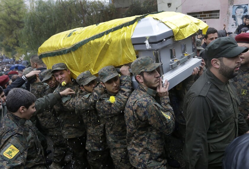 Hezbollah fighters carry the coffin of Hassan Holo Laqqis, a senior commander for the Lebanese militant group who was gunned down outside his home. His funeral procession took place in Baalbek city, in eastern Lebanon.