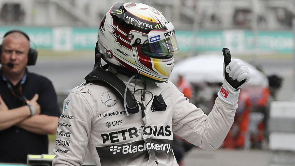 Lewis Hamilton celebrates after finishing first in qualifying for Sunday's Formula One Grand Prix of Malaysia.