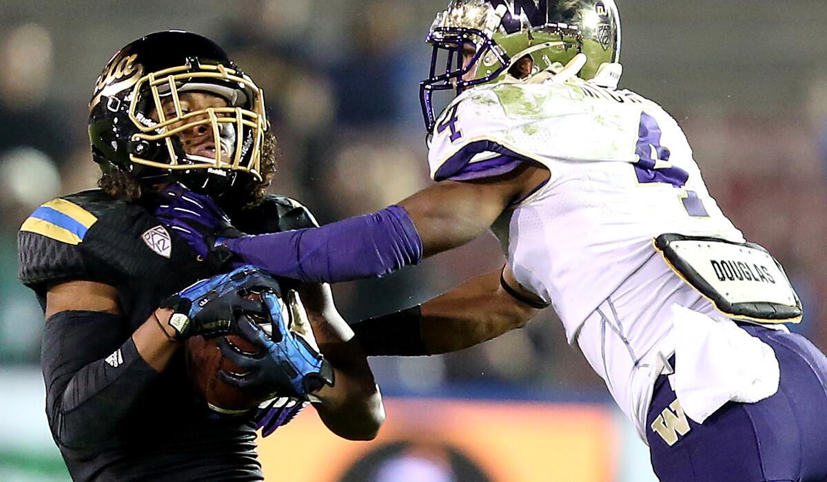 UCLA defensive back Randall Goforth intercepts a pass intended for Washington receiver Jaydon Mickens during a game last season at the Rose Bowl.