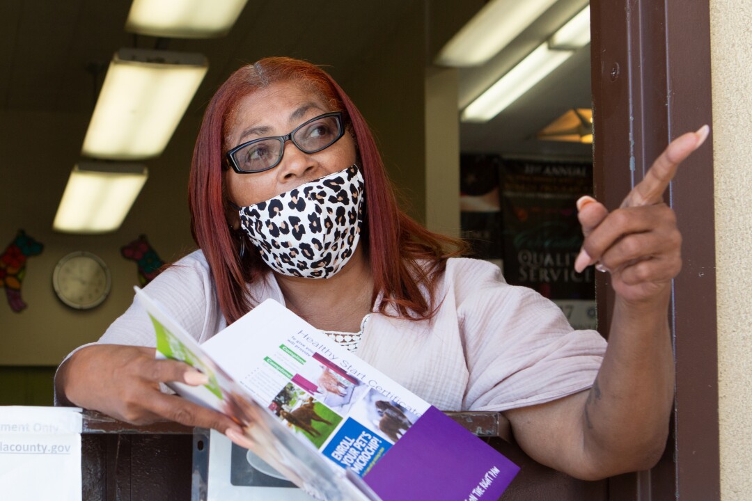 Sheryl Theriot, a clerk at a Los Angeles County Animal Care and Control shelter, helps a customer adopt a dog.