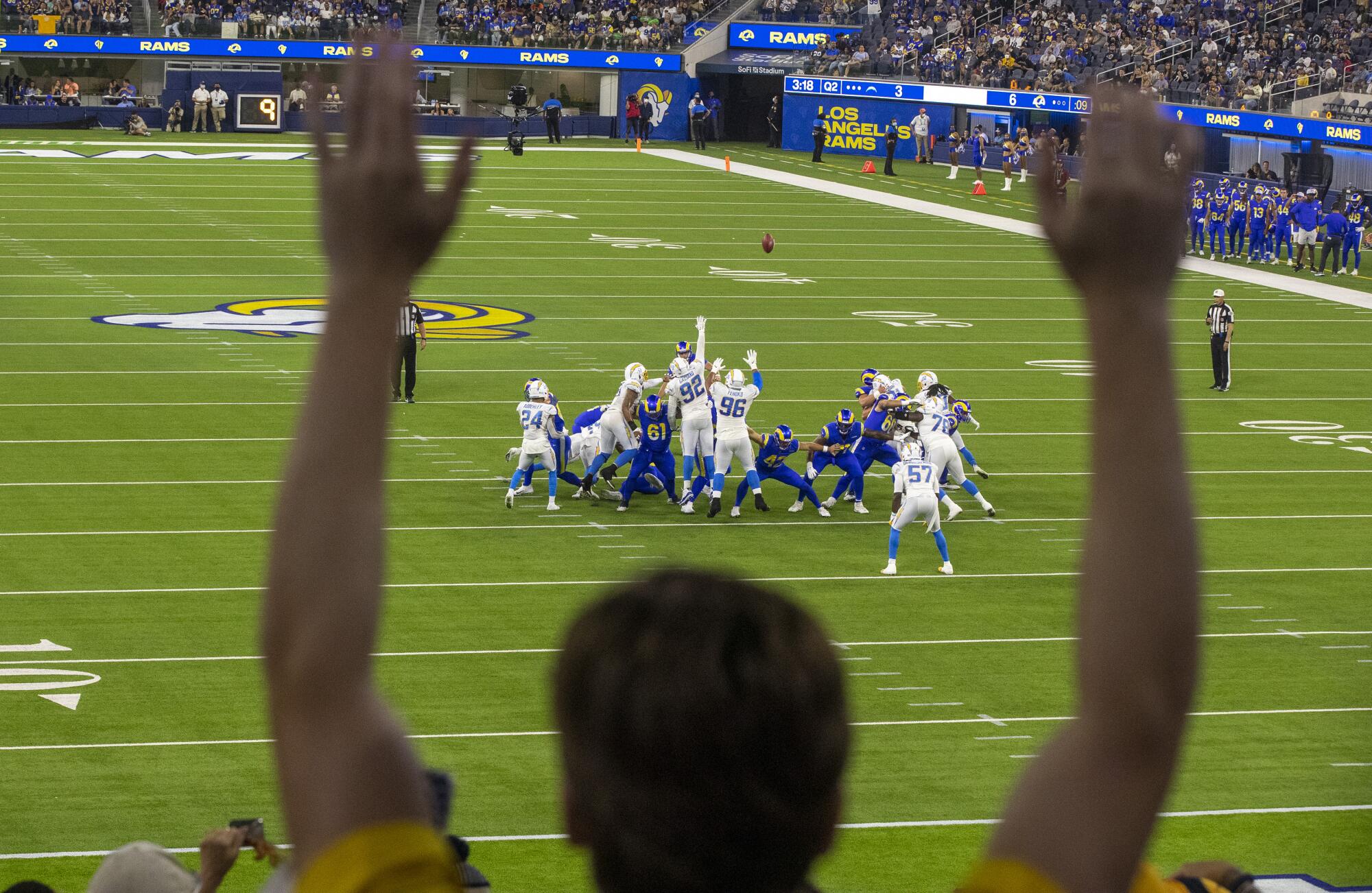 Fans watch at SoFi Stadium as the Rams attempt an extra point during a preseason game against the Chargers.