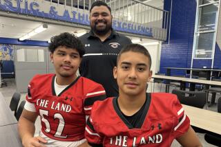 First-year Cleveland coach Mario Guzman with lineman Joshua Reyes (left) and quarterback Domenik Fuentes.