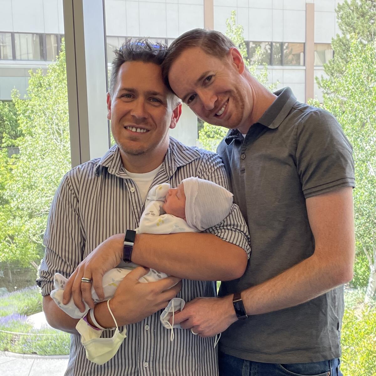 Adam Swain Ferguson with his partner Kevin and their son Taran after he was born.