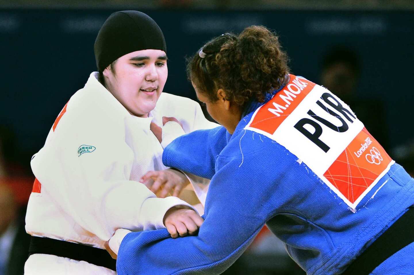 Saudi Arabia's Wojdan Shaherkani, in white, faces Puerto Rico's Melissa Mojica in judo.