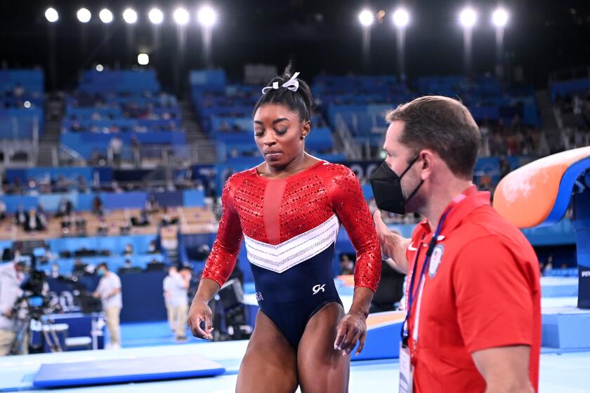 Simone Biles leaves the floor after competing on the vault during the women's team gymnastics