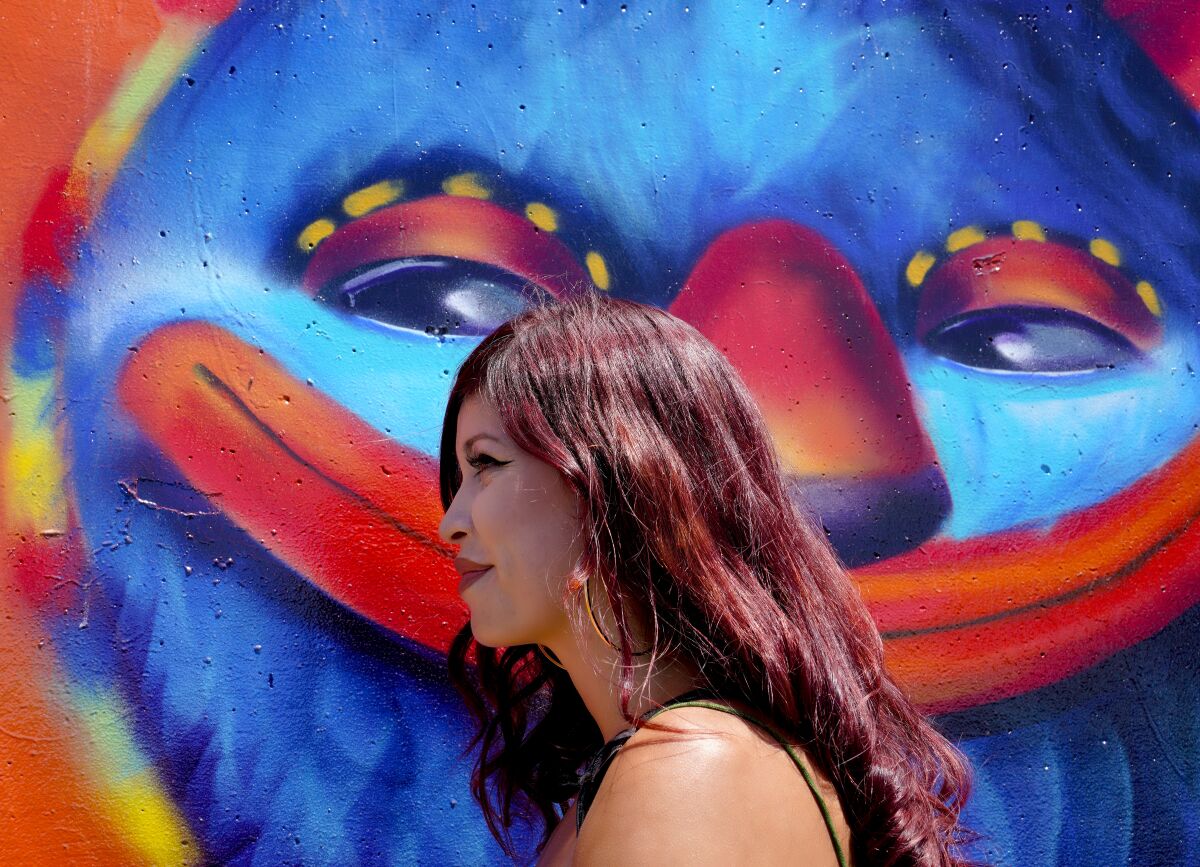 Local artist, Michelle Guerrero, next to a large wall mural that she painted in Chula Vista.