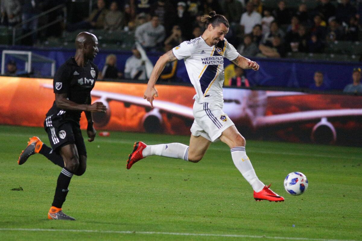 CARSON, CA - APRIL 08: Zlatan Ibrahimovic #9 of Los Angeles Galaxy dribbles past Ike Opara #3 of Sporting Kansas City toward the goal during a game against Sporting Kansas City at StubHub Center on April 8, 2018 in Carson, California.